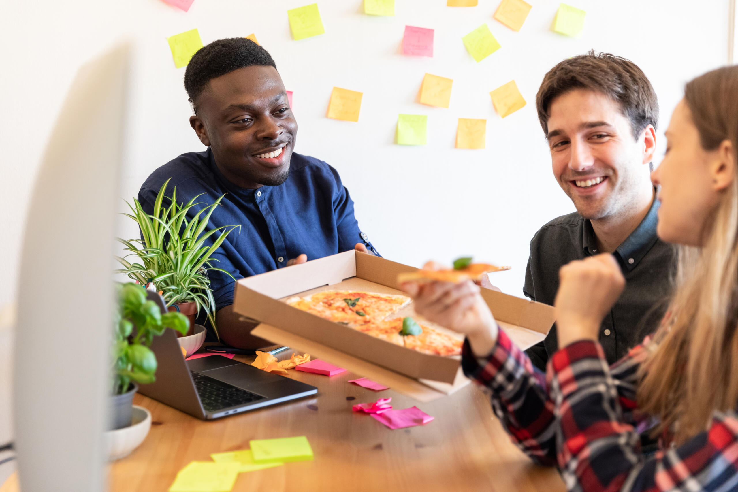 The secret to preventing employee burnout: employees share pizza at collaborative working area